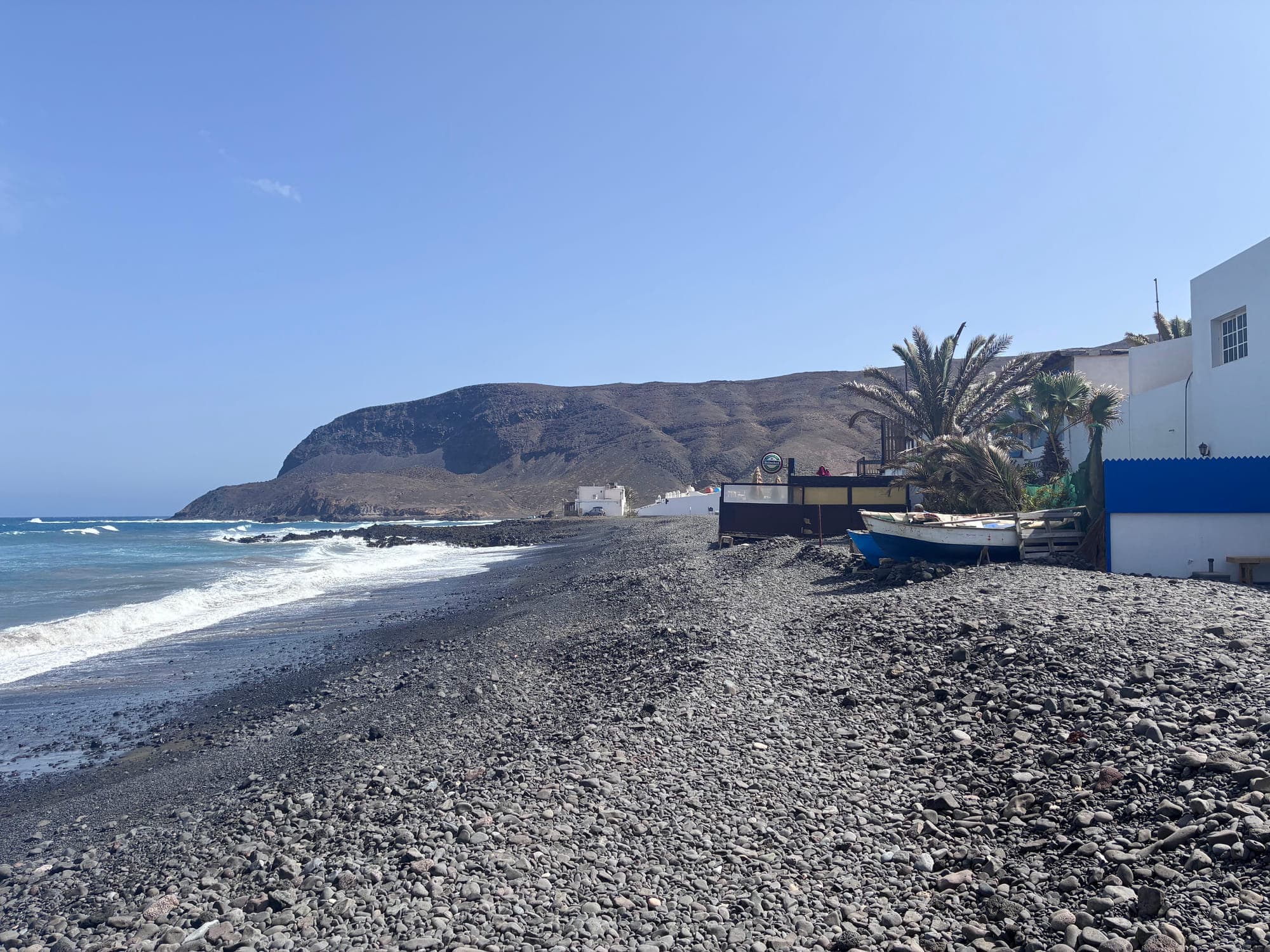Rocky cove with fishing boats and mountain