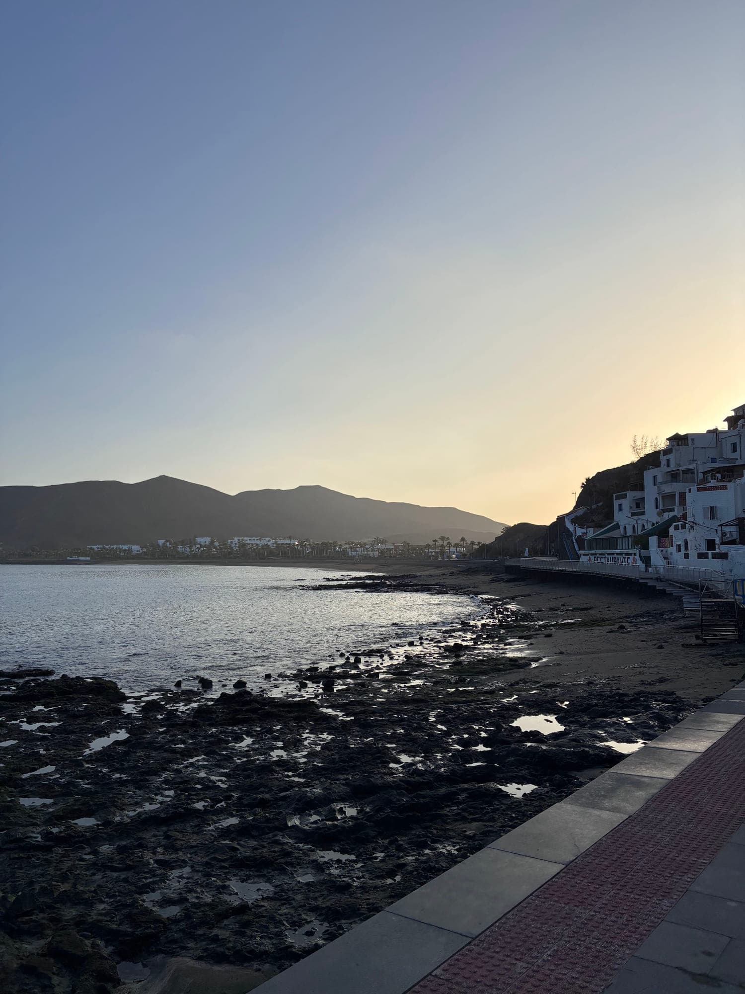 Sunset over the coastal town and rocky shore